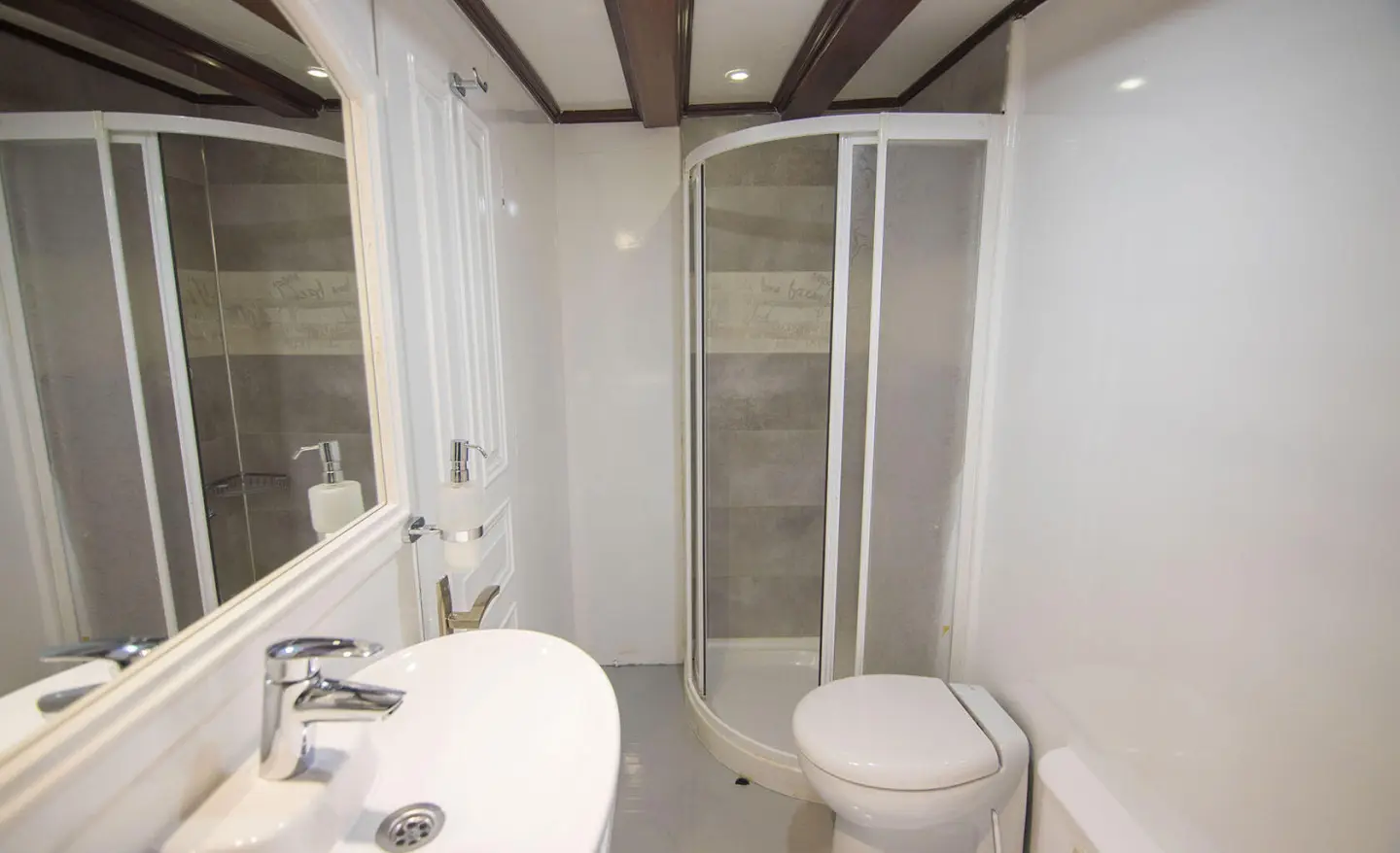 Grande Mare yacht bathroom interior with curved shower enclosure and white fixtures