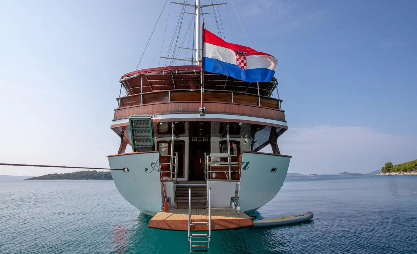 Rear view of Amorena luxury motor yacht anchored in calm turquoise water