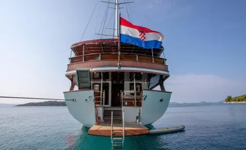 Rear view of Amorena luxury motor yacht anchored in calm turquoise water