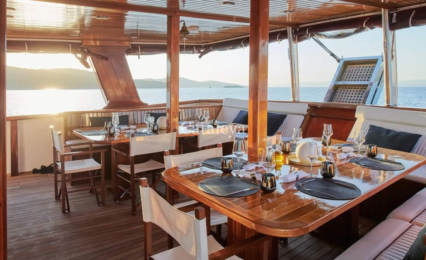 Yacht Cataleya dining deck set for sunset meal under shaded canopy on calm sea