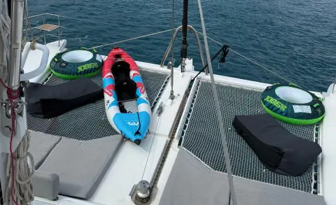 Atlantis yacht deck with a blue and white lifebuoy on a railing at sunset