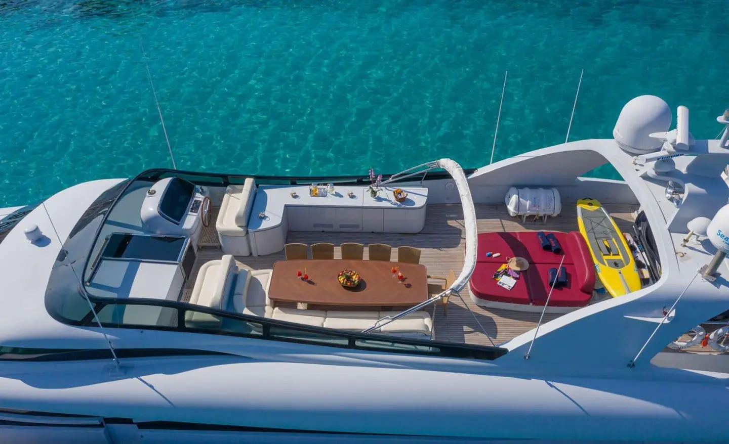 Wide open deck with dining table and seating, sea view in background