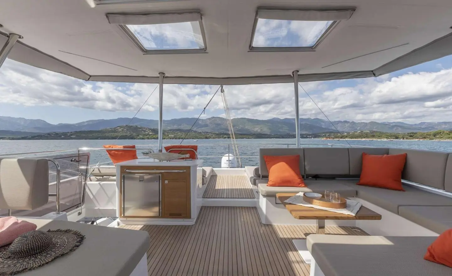 Serenissima yacht deck seating area with orange cushions and large windows