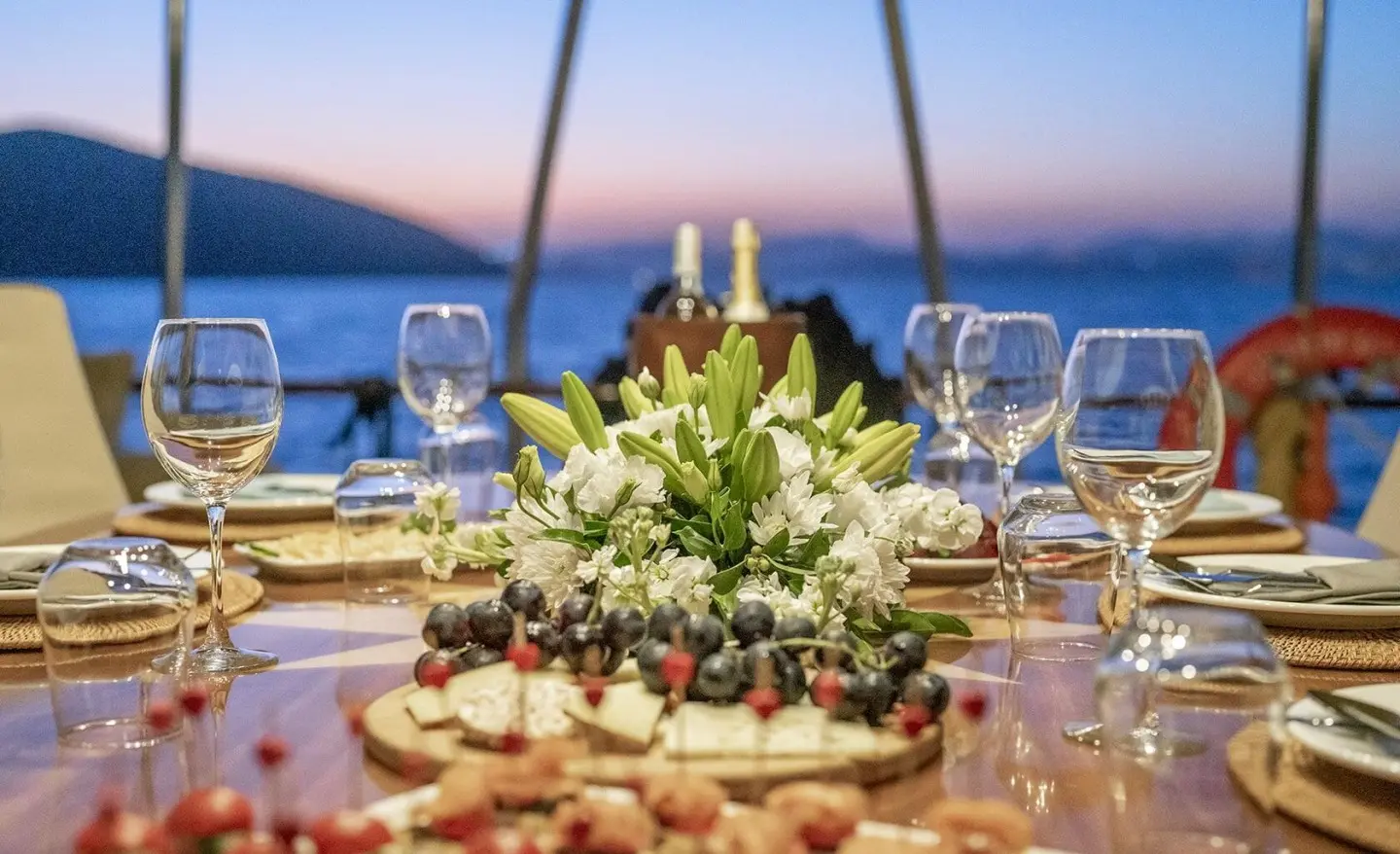 Queen Of Sea gulet deck table set with pastries, flowers, and glasses