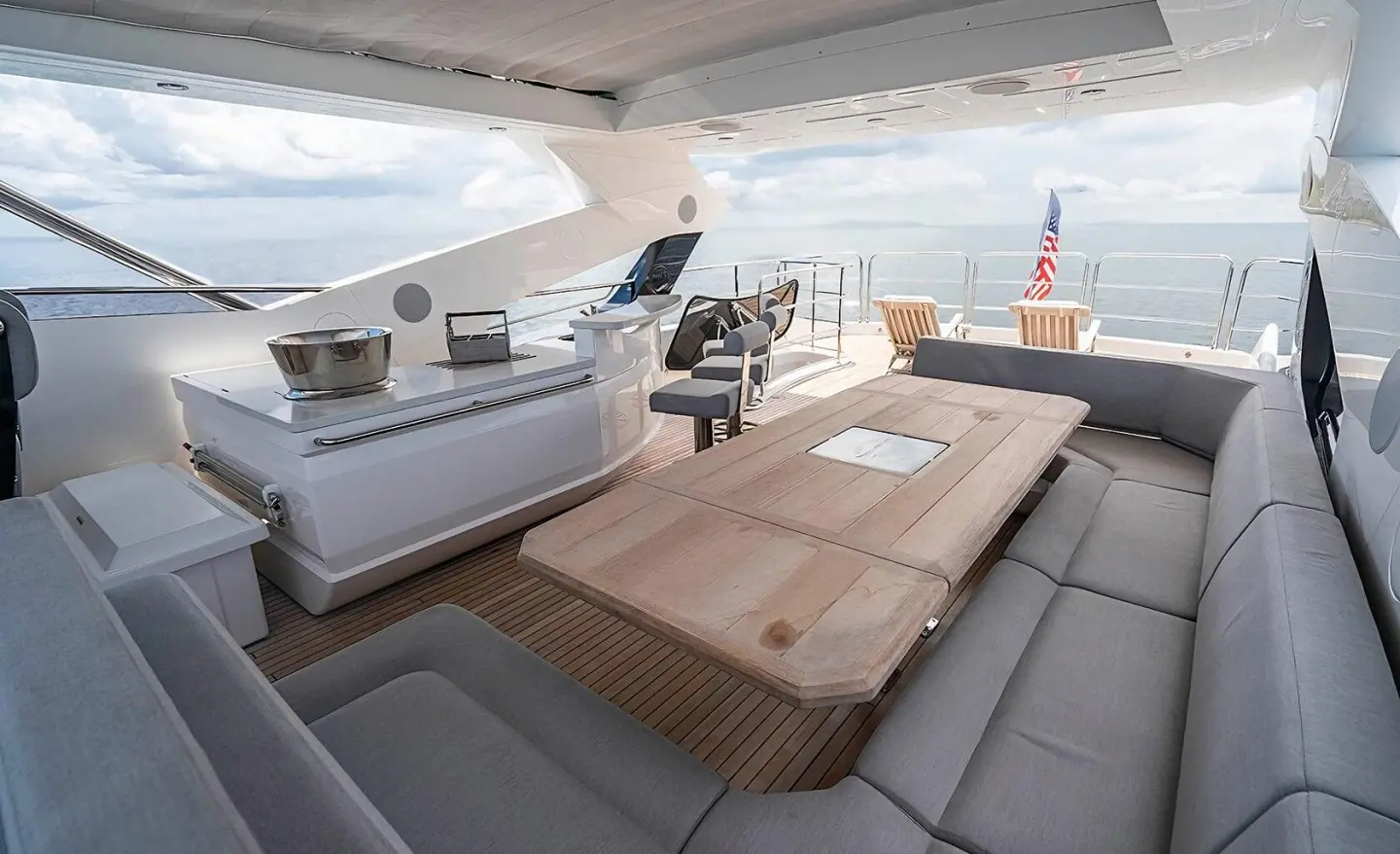 Open cockpit of Quantum yacht with seating area and dining table overlooking the sea