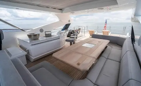 Open cockpit of Quantum yacht with seating area and dining table overlooking the sea