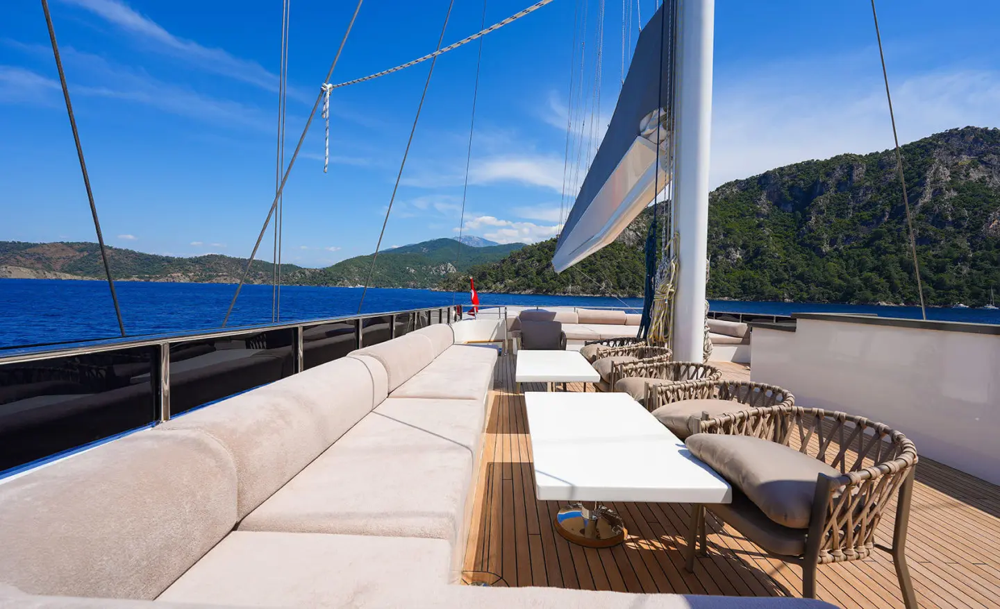 Luxurious yacht deck at sunset with cushioned seating and steering lines