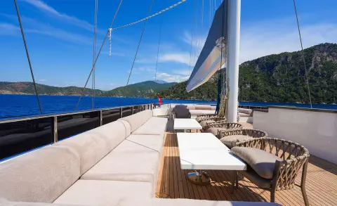 Luxurious yacht deck at sunset with cushioned seating and steering lines