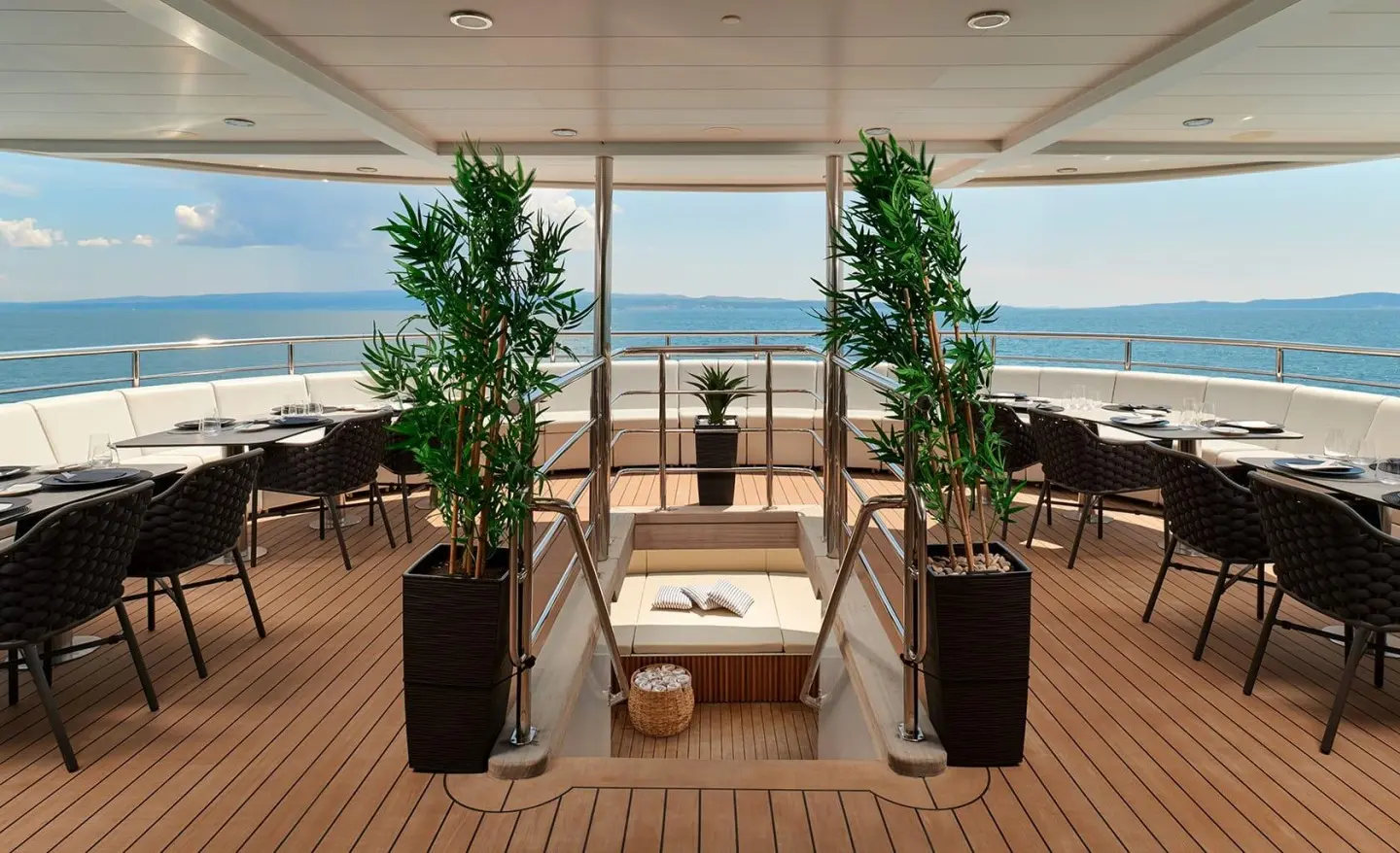 Ohana yacht dining area on deck at sunset with table and chairs, ocean view