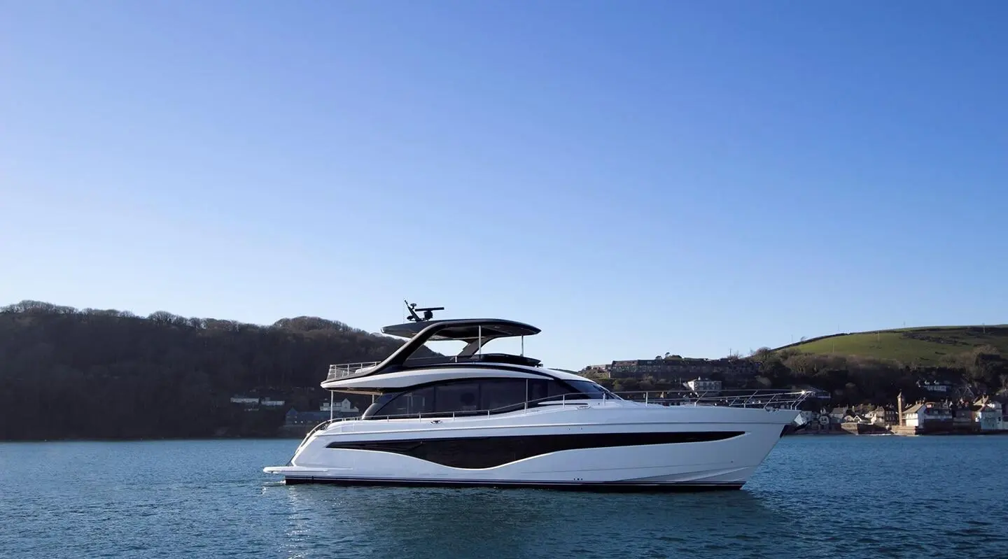White motor yacht anchored on calm water, side profile with sleek lines