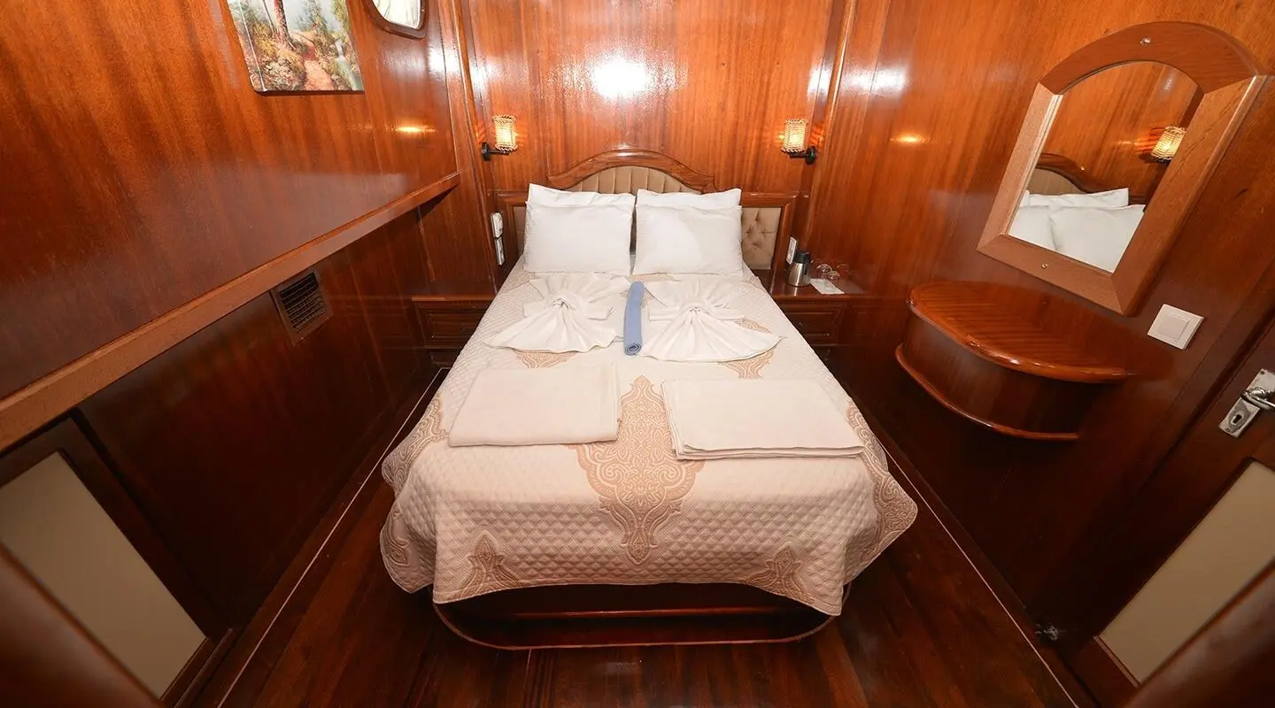 Interior cabin on a luxury yacht with polished wood walls and bed