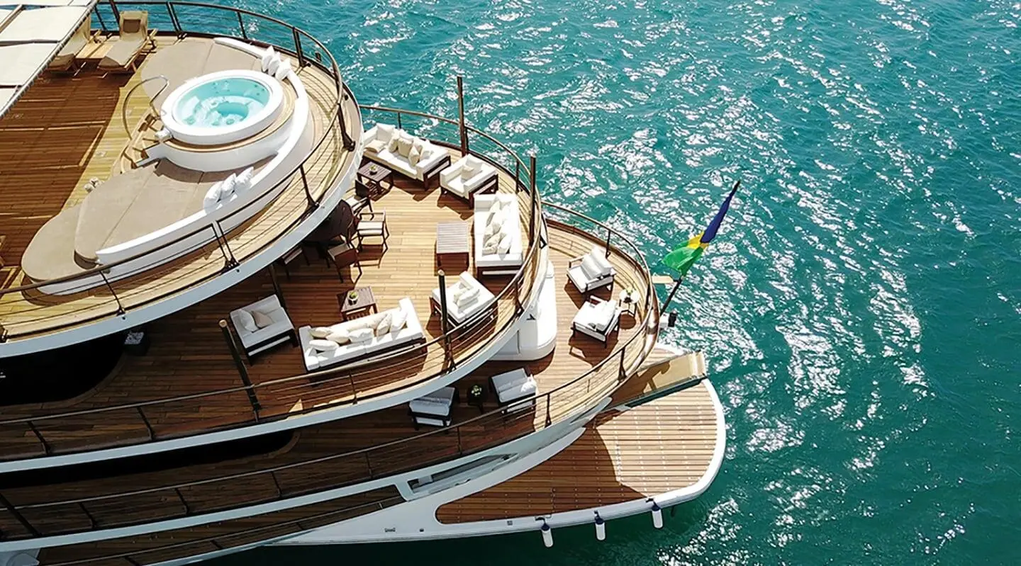 Chakra luxury yacht seen from above at dock, sunlit wooden deck and bright water