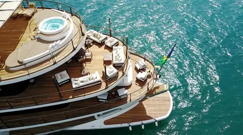 Chakra luxury yacht seen from above at dock, sunlit wooden deck and bright water