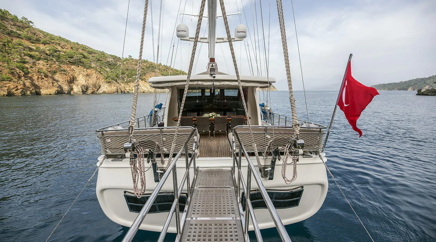 Kayhan 3 luxury gulet at sunset, view from stern with ropes and deck ladder