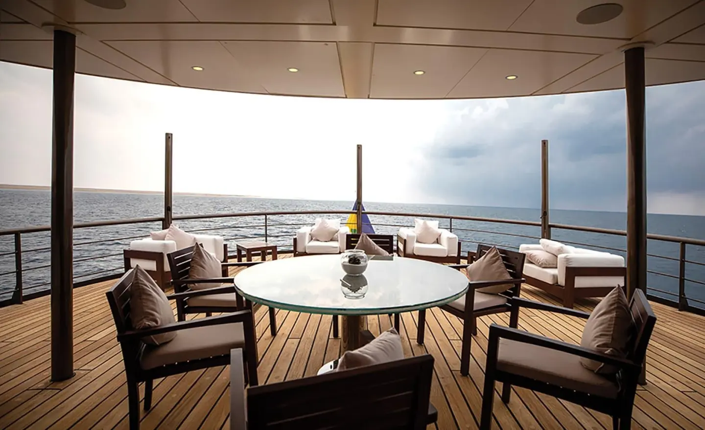 Chakra luxury yacht deck seating area at sunset with table and ocean view