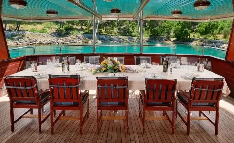 Luna yacht outdoor deck with four red wooden chairs facing turquoise water
