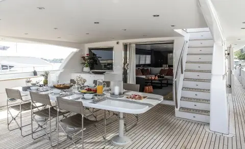 Project Steel yacht deck dining area with table set and built-in seating