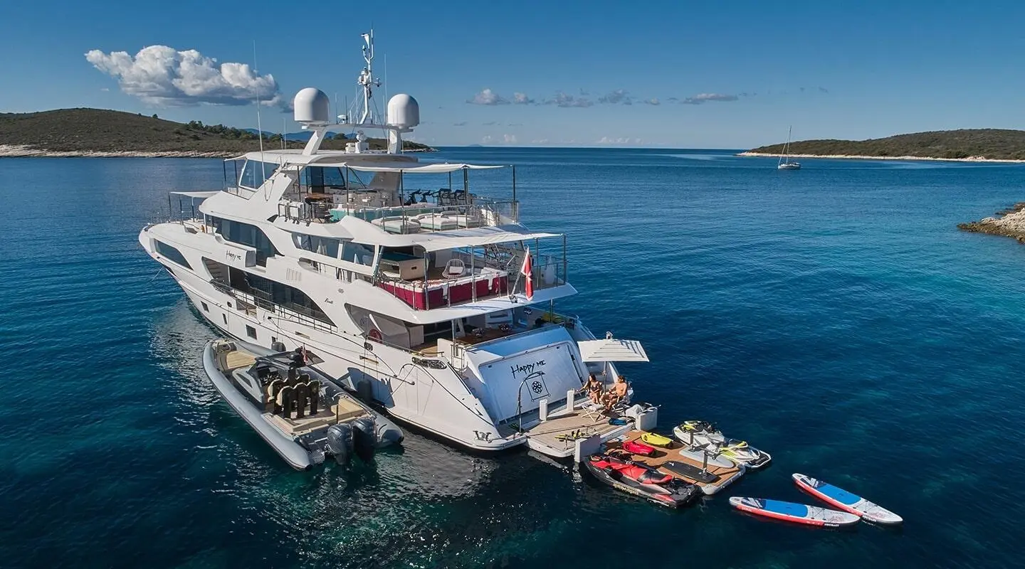 Happy Me yacht anchored with multiple decks towering over blue sea
