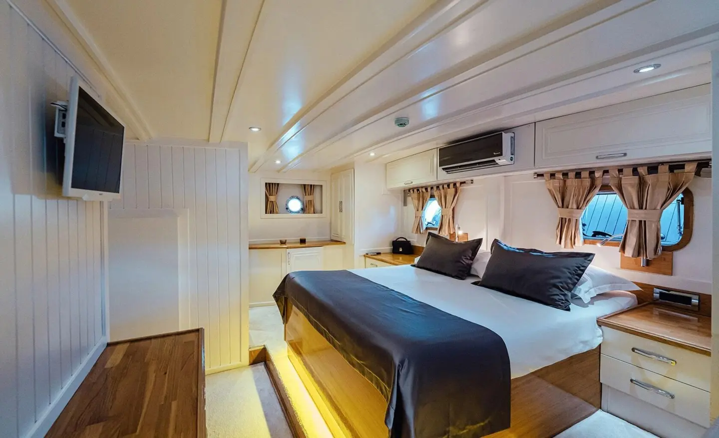 Interior of Maske gulet: double cabin with blue bed, white walls, wooden accents
