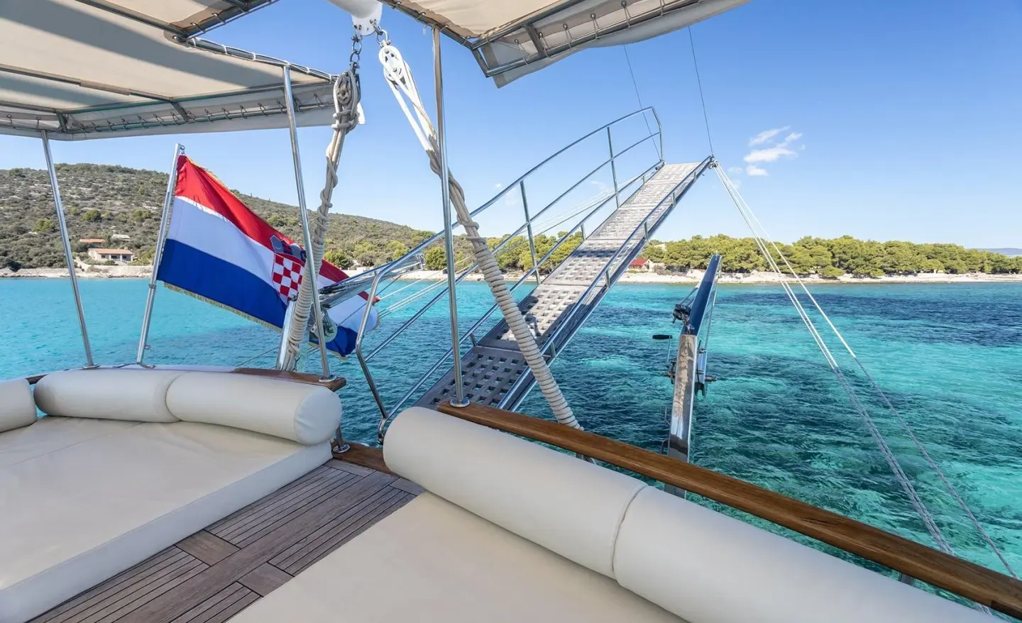 Andi Star luxury gulet sailing at sunset, deck seating and railings overlooking calm sea