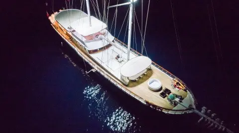 Gulet Halcon Del Mar at night, moored alongside with lights reflecting on calm water
