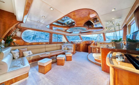 Luxurious Lotus yacht interior: cream leather seating, polished wood panels, glass windows with ocean view