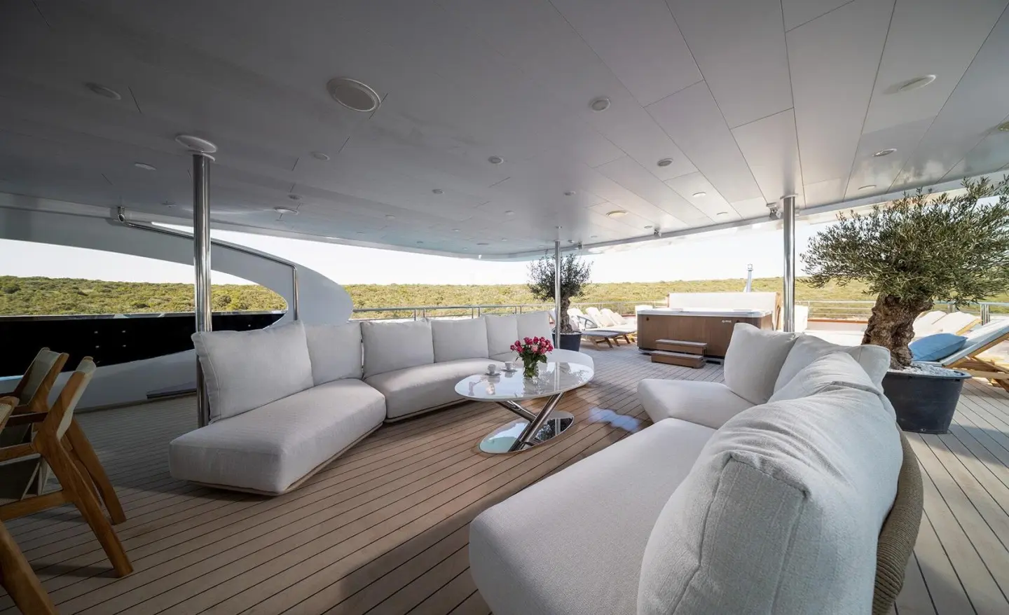 Olimp motor yacht lounge deck with white cushioned seating and glass table