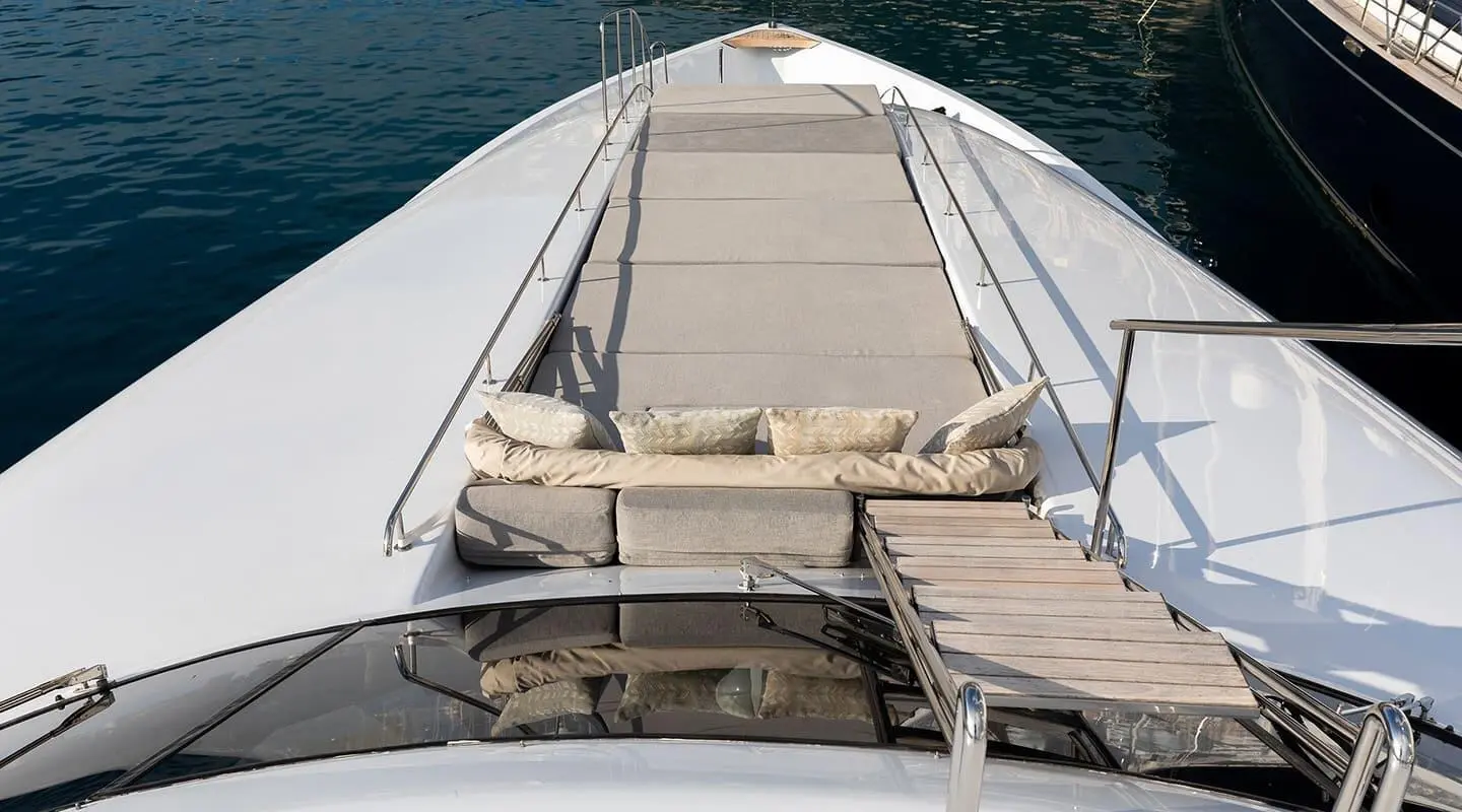 Open foredeck with cushioned seating and a walkway on the yacht