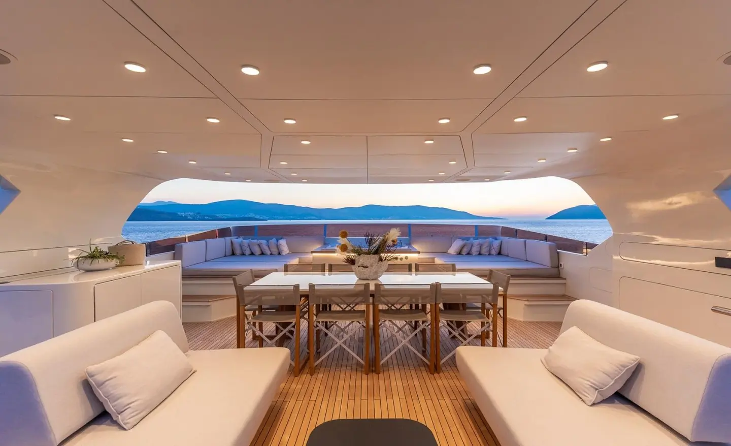 Illusion II yacht interior with sunlit helm, wooden deck, and seating area