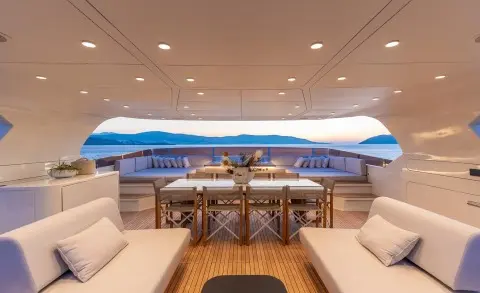 Illusion II yacht interior with sunlit helm, wooden deck, and seating area