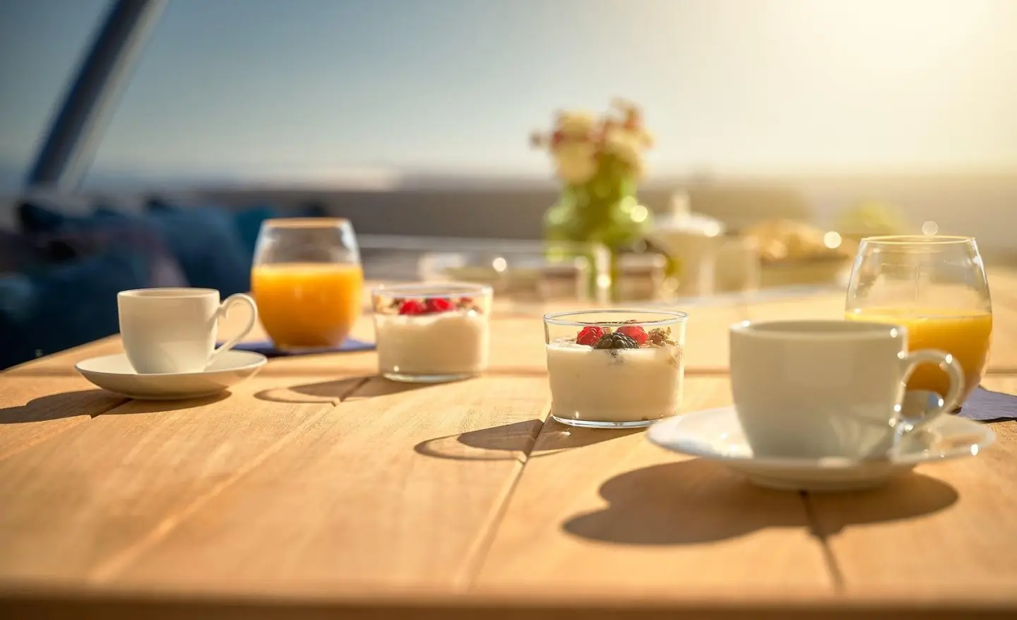 Sunset dining on Hideaway: wooden table with glasses and plates aboard