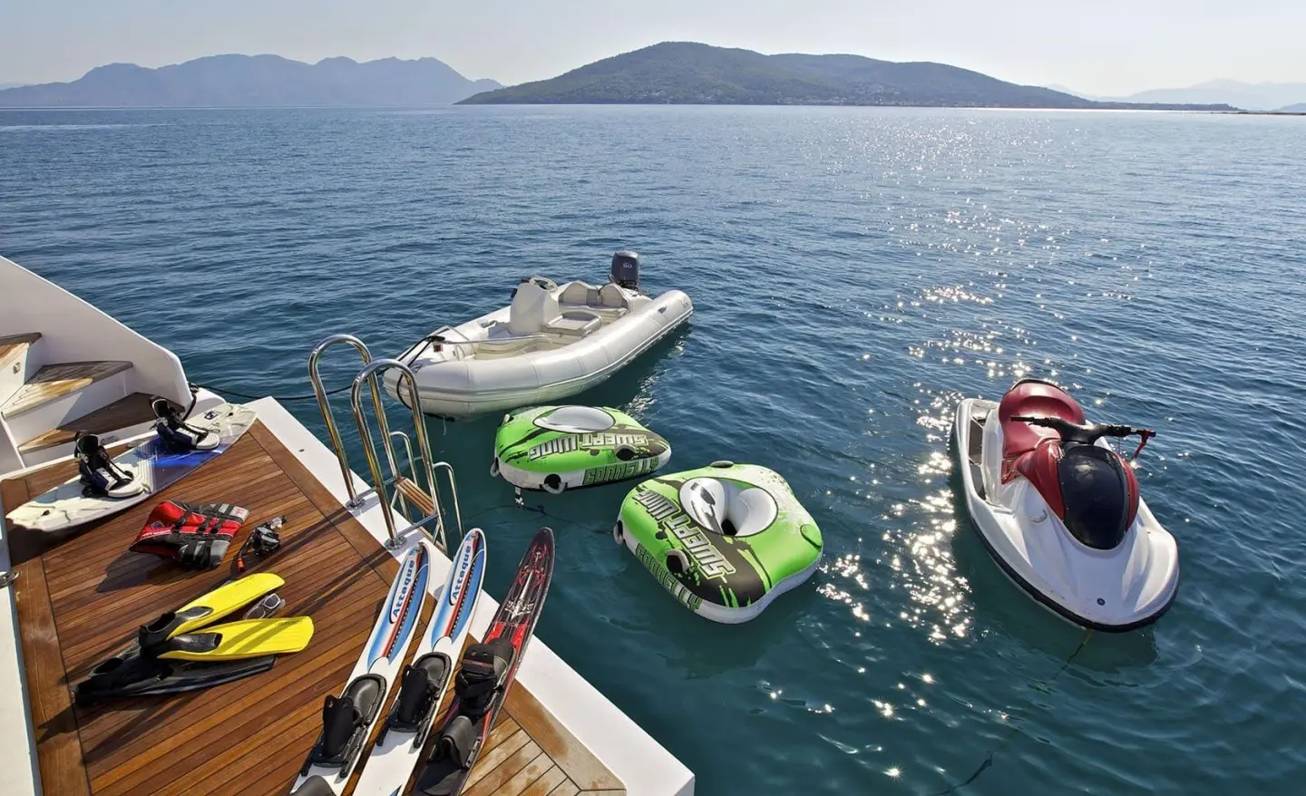 O'Rion yacht seen from a dock with small colorful inflatable and jet ski