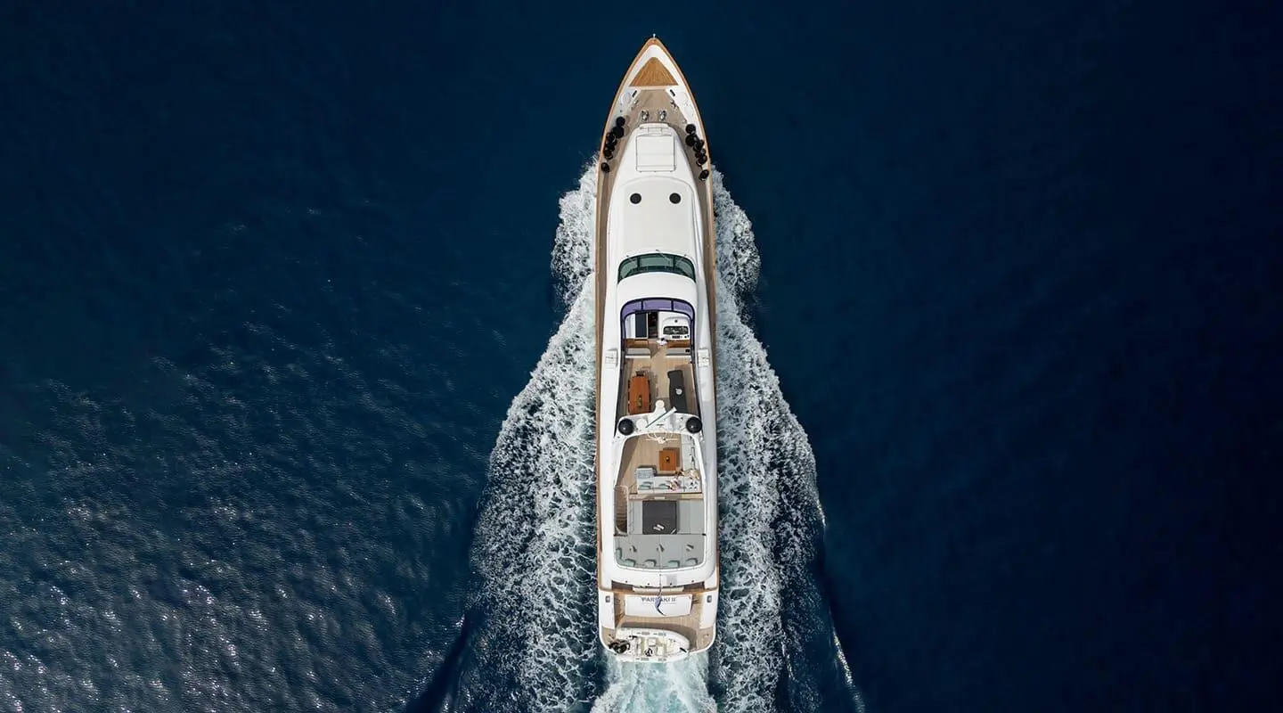 Aerial view of Pareaki II motor yacht cruising, white hull slicing blue sea