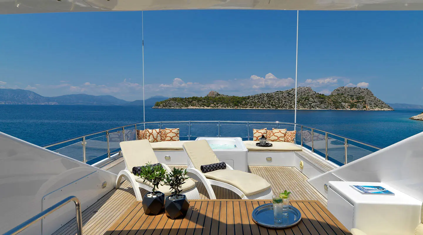 Yacht Idylle sun deck with seating, table, and sea view from bow area