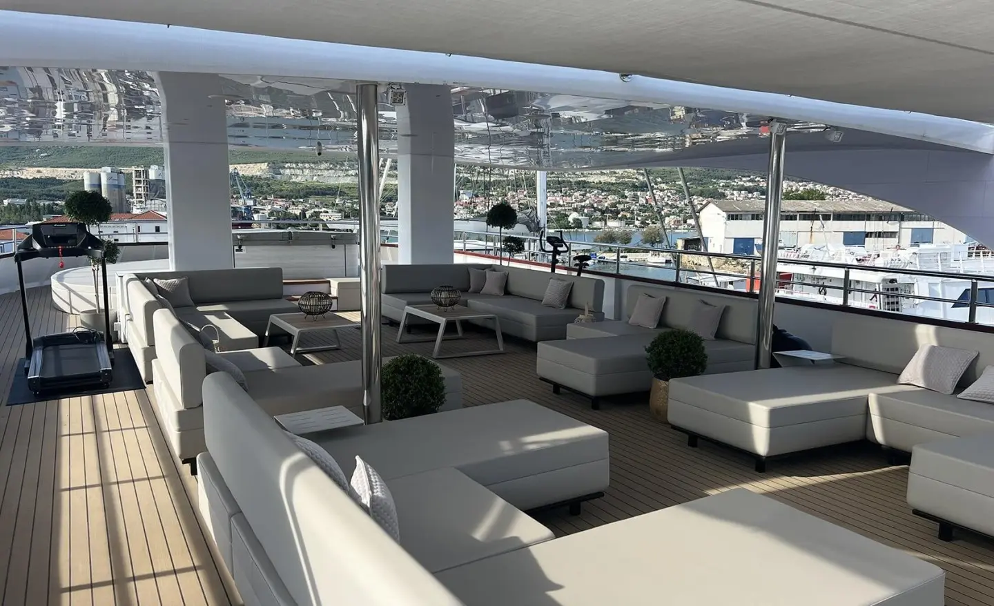 Salon on Melody yacht with cream seating, glass windows, and outdoor marina view