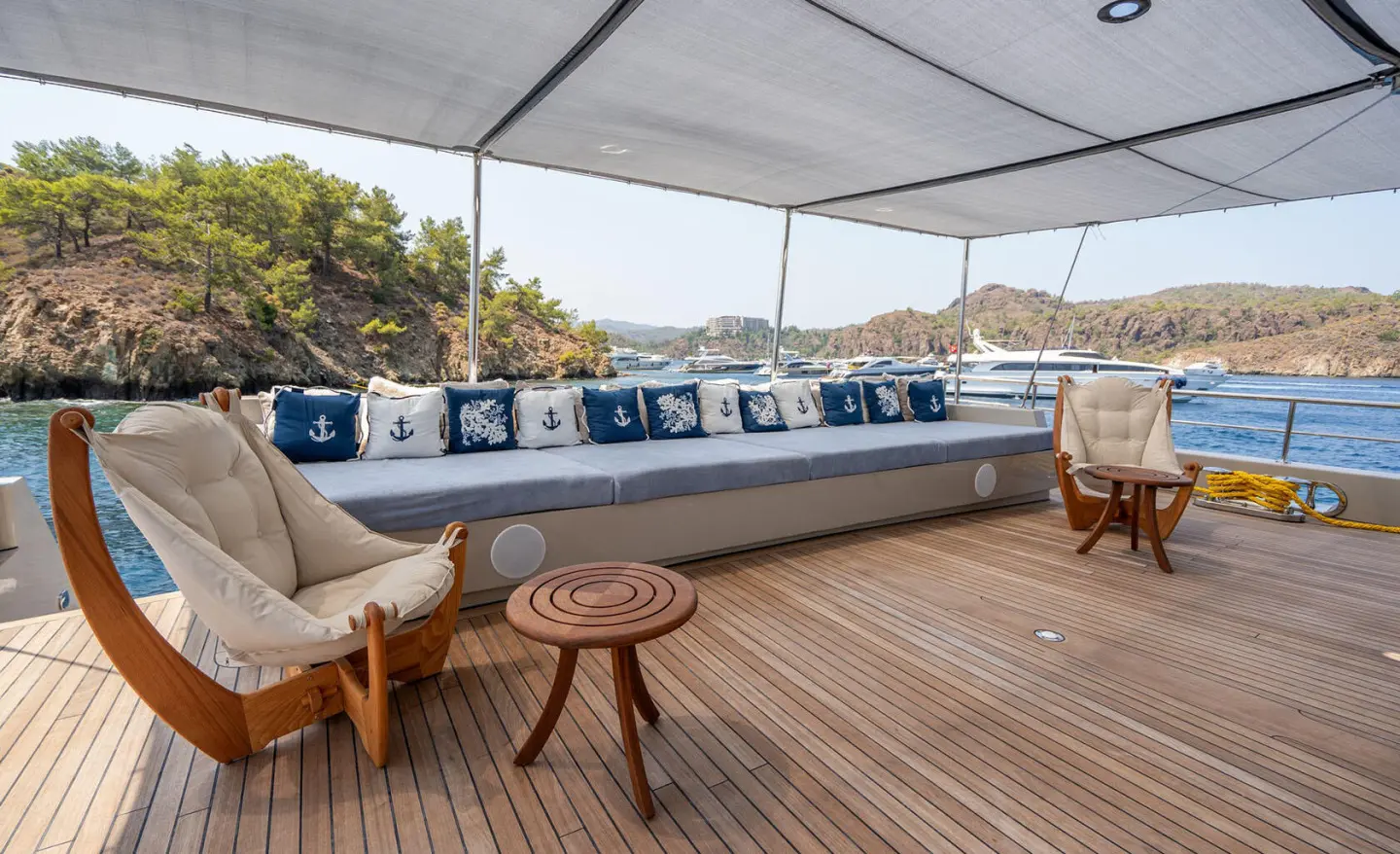 Deck of luxury yacht De Love with seating, parasol, and blue water backdrop