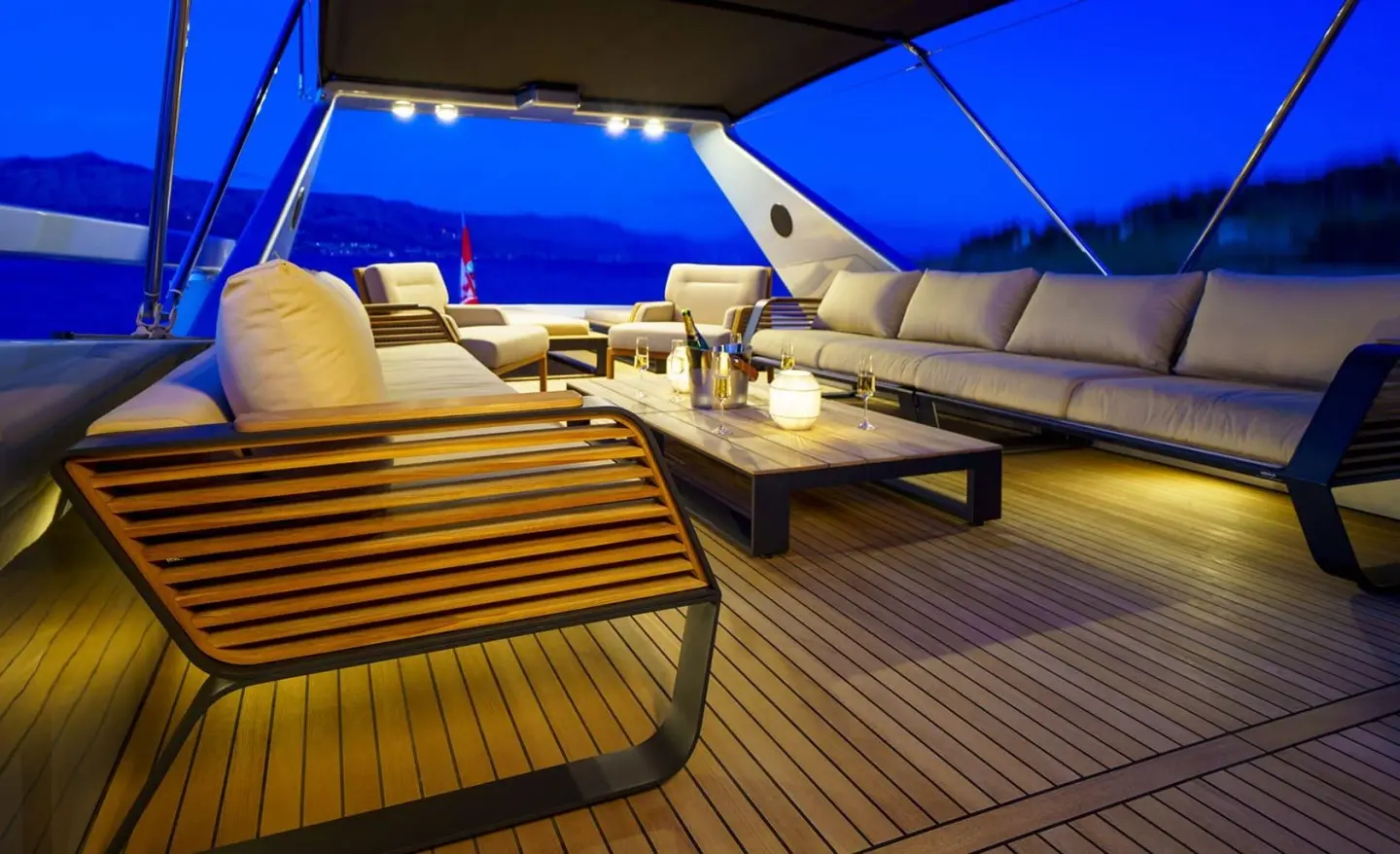 Phantom motor yacht at night with illuminated deck under blue sky