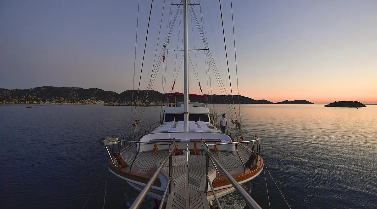 Blu Dream yacht deck view at sunset with sails and calm sea waters