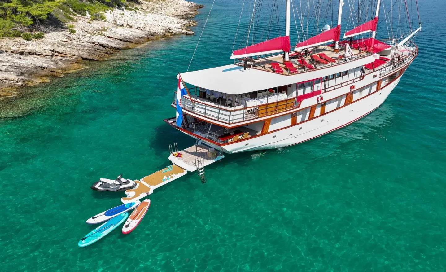 Barbara yacht at sea with red sunshades and lounge chairs on the upper deck