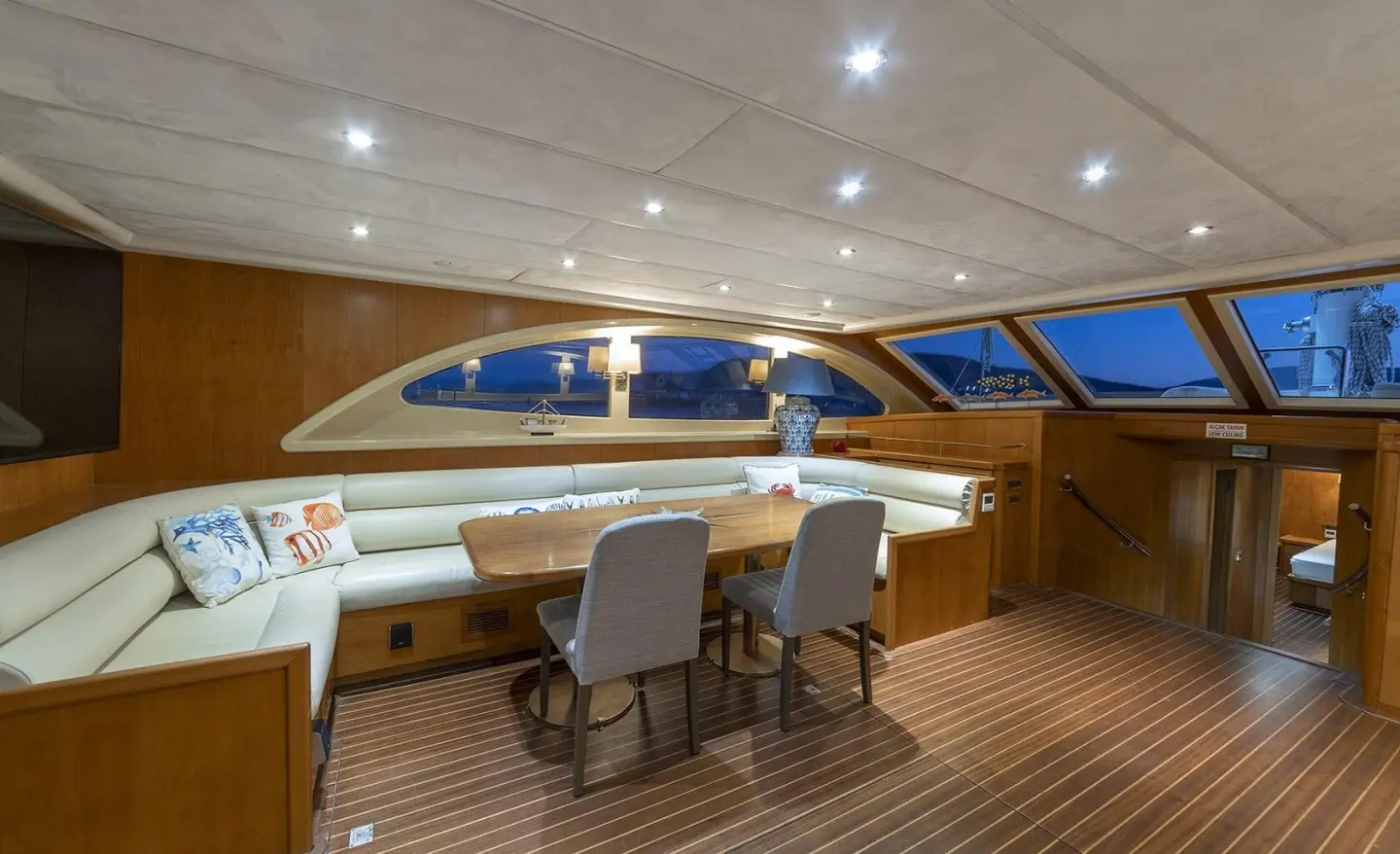 Queen Of Sea yacht on deck at sunset, wooden floor, seating area, Italian-style helm.