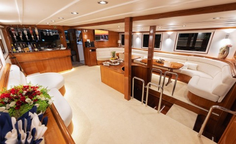 Interior lounge area with wooden bar, white upholstered seating and coffee table