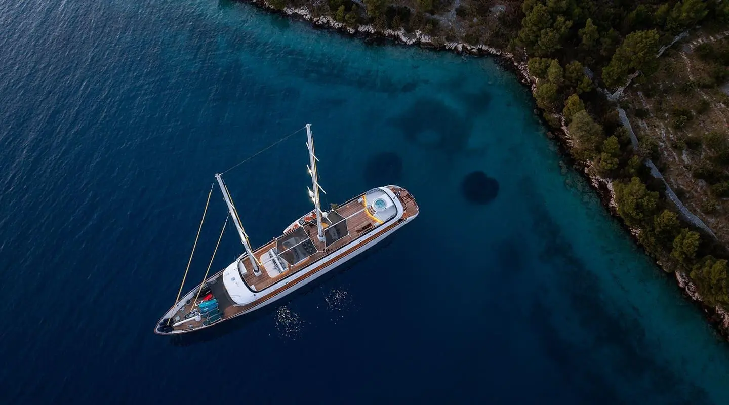 Aerial view of a luxury yacht named Anima Maris moored at sunset