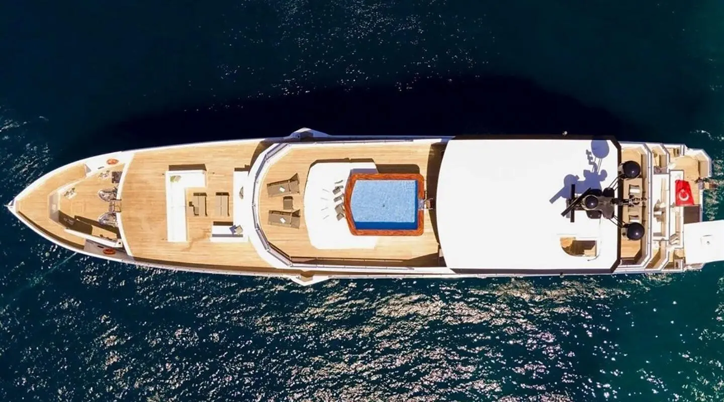 Top-down view of Ocean Breeze deck with seating and sun loungers on water