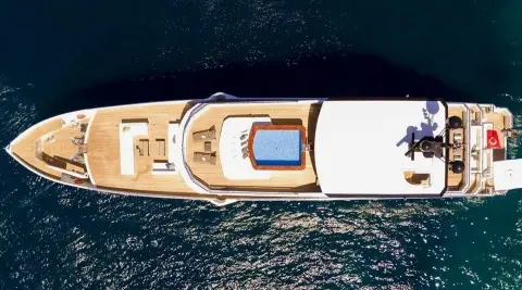 Top-down view of Ocean Breeze deck with seating and sun loungers on water