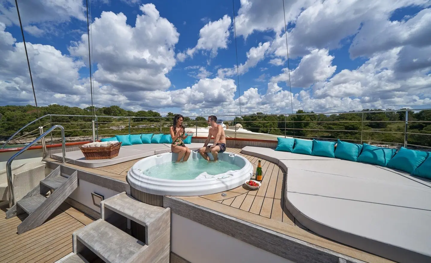 On a sunny outdoor deck, a luxury yacht's jacuzzi with turquoise cushions along the edge