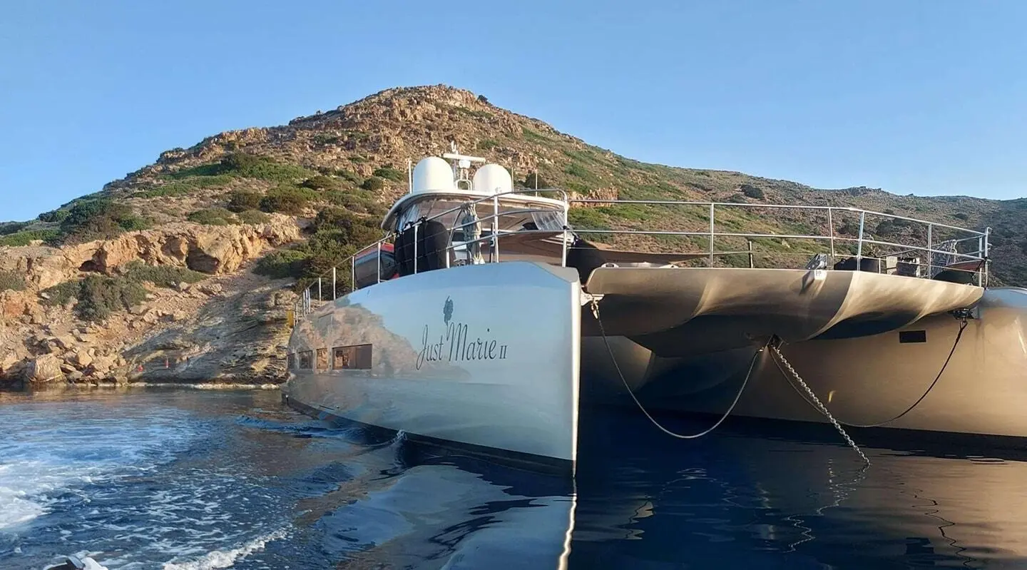 Just Marie 2 yacht anchored near rocky coast with calm blue sea backdrop