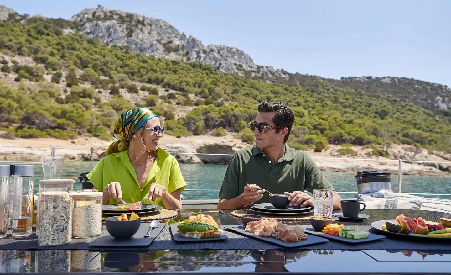 On the Aizu motor yacht's sunlit deck, a couple dining together
