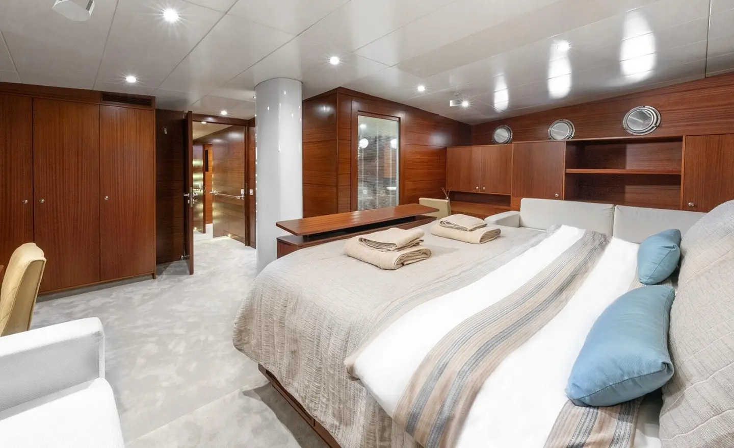 Luxurious yacht master cabin with wood wardrobes and decorative pillows