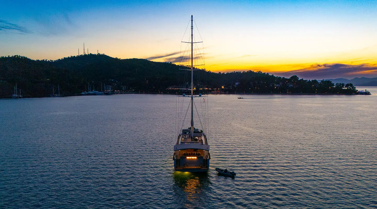 Sailing yacht King Of The Sea anchored at sunset on calm water