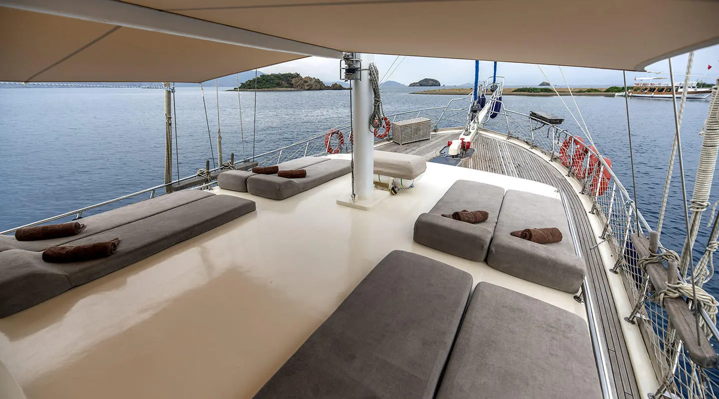 Faralya yacht on calm sea with shaded deck loungers and coast ahead